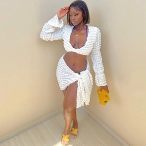 White two-piece set featuring a bubble texture crop top and side-tie mini skirt