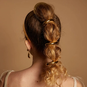 Golden stainless steel hair ring accessory worn on an elegant ponytail hairstyle