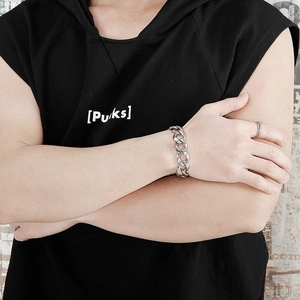 Close-up of men's chunky titanium steel Cuban chain bracelet and ring in punk style