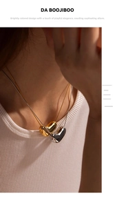 Detail of 18k gold and silver heart pendants on snake chains with mirror finish