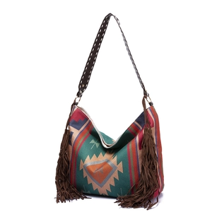 Detail of bohemian woven shoulder bag with colorful textures and long brown fringes