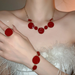 Gros plan sur l'ensemble collier, bracelet et bague en émail rouge sur le mannequin