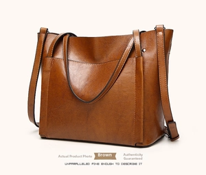 Detail view of brown wax leather tote bag with reinforced handles and metal rivets