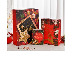 Three sizes of red Christmas gift bags with gold foil patterns and Merry Christmas text