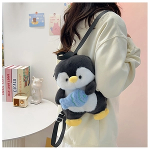Detail of cute plush penguin backpack with adjustable straps and blue fish accessory