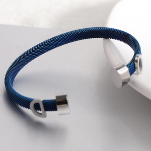 Macro shot of 6mm blue wire cable bracelet showing polished silver D-letter end detail