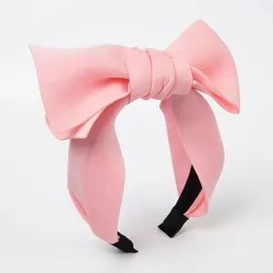 Serre-tête à gros nœud rose en tissu lisse pour un style de coiffure volumineux chic