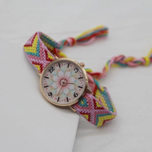 Macro shot of bohemian woven strap watch featuring a floral lotus dial and tassel