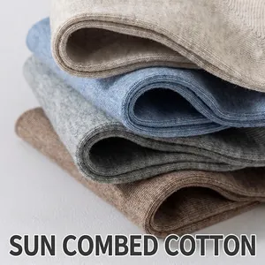 Stack of multi-colored combed cotton ankle socks with soft knitted texture for men