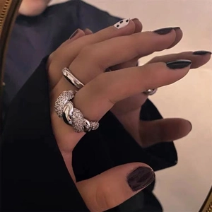 Silver twist ring with cubic zirconia paired with sleek polished band on model hand