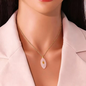 Collier élégant doré avec pendentif en pierre rose taille marquise porté par modèle