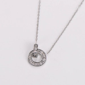 Close-up of silver stainless steel double ring pendant with baguette zircon stones