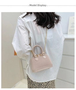 Detailed view of pink shell-shaped jelly bag with pearl texture and gold chain strap