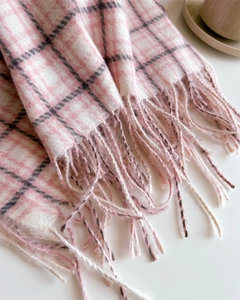 Macro shot of pink and white plaid scarf with fringe detail and cashmere-like texture