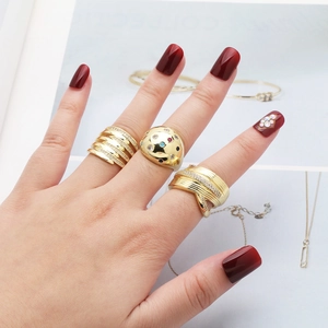 Detail of three layered gold rings with cubic zirconia and colored gemstones on model hand