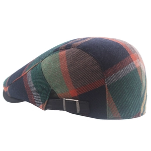 Detail view of colorful plaid beret featuring an adjustable side metal buckle