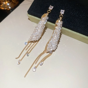 Detailed shot of gold tassel earrings with shimmering crystals and long hanging chains