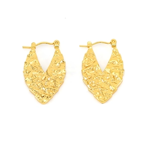 Detailed view of gold leaf shaped earrings with vintage hammered metal texture on white background