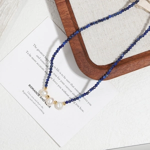 Minimalist handmade beaded necklace with dark blue lapis stones and baroque pearls
