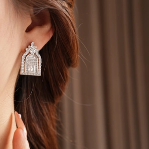 Close-up of silver geometric oval stud earring with sparkling cubic zirconia on a model