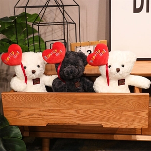 Three plush teddy bears holding red hearts in a wooden drawer with home decor