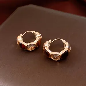 U-shaped gold resin earrings with amber rhinestones and clear crystals on leather