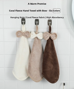 Hanging coral fleece hand towels with bow details in white, beige, and brown colors