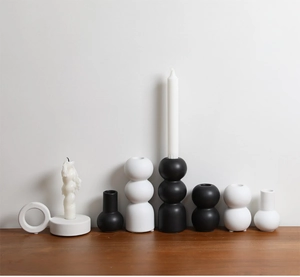 Close-up of minimalist black and white ceramic candle holders with geometric shapes on wood
