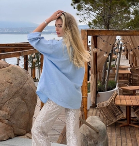 Buitenfoto van een lichtblauwe blouse met lange mouwen en zilveren paillettenbroek