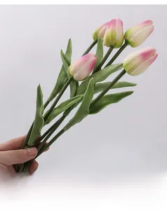 Close-up of artificial pink gradient tulips with green leaves for home decoration