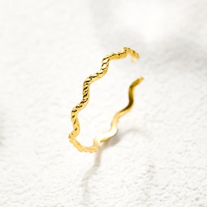 Close-up of 18K gold plated stainless steel ring with wave twisted open design