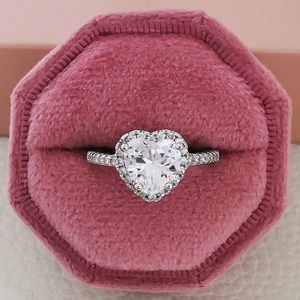 Elegante anillo de corazón con diamantes halo en un estuche de terciopelo rosa