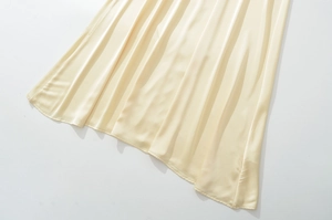 Détail de l'ourlet en satin champagne montrant la texture de soie et le drapé élégant