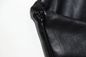 Dettaglio della cerniera invisibile e della texture in ecopelle sul vestito nero