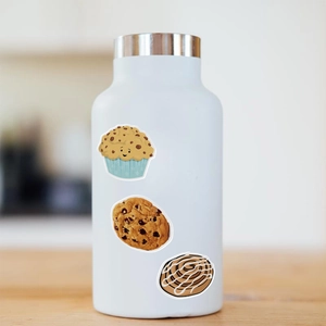 Waterproof food stickers featuring muffins and cookies applied to a white metal water bottle