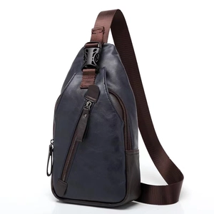 Detail of blue and brown leather crossbody chest bag with adjustable strap and zip pocket