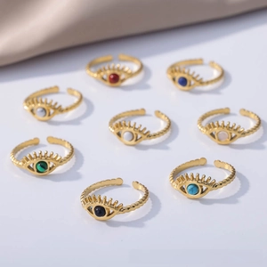 Detail of evil eye adjustable gold rings with vibrant gemstones and rope texture