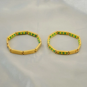 Detailed view of gold chain bracelet featuring alternating yellow and green beads