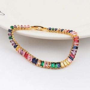 Detailed macro view of gold-plated chain bracelet with multi-color rectangular zircons