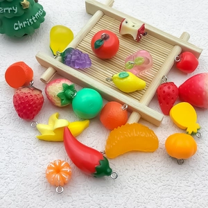 Flat lay of colorful 3D resin fruit and vegetable charms for DIY crafts and jewelry