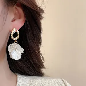 Details von Vintage Blumenohrring mit goldenem Hammerschlag-Ring und weißen Blüten