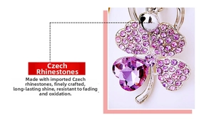 Detailed close-up of a silver four-leaf clover keychain with purple crystals and rhinestones