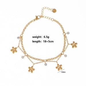 Detail of gold double-layer anklet featuring flower charms and clear round zircons