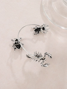 Detail einer Vintage-Silber-Ohrmanschette mit aufwendigem Skorpion- und Käferdesign