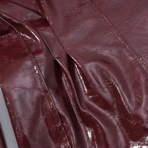 Dettaglio della giacca in pelle PU rosso scuro che mostra la grana e la qualità delle cuciture