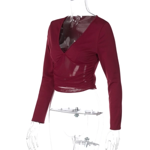 Détail du haut rouge à col en V avec empiècement en résille et texture plissée