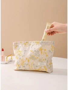 Trousse à maquillage en lin beige brodé avec main rangeant un produit de soin