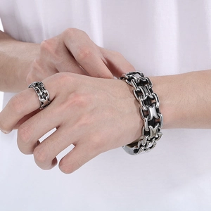 Close-up of silver-toned stainless steel link chain bracelet and matching ring on model