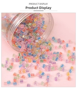 Close-up of colorful 5mm square glass beads spilled from a container for DIY jewelry