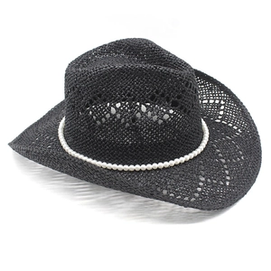 Close-up of black straw cowboy hat featuring elegant pearl band and woven texture